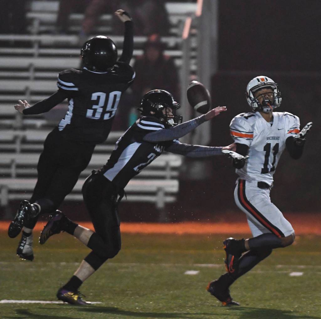 Juneaus Cody Requa, left, and James Connally disrupts a pass to Wests Malyk Davis in the third quarter at Adair-Kennedy Memorial Field on Friday, Sept. 13, 2019. West won 43-14. (Michael Penn | Juneau Empire)