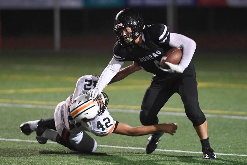 Juneaus Ali Beya, right, runs against Wests Romeo Vaimili in the third quarter at Adair-Kennedy Memorial Field on Friday, Sept. 13, 2019. West won 43-14. (Michael Penn | Juneau Empire)