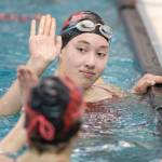 Juneau-Douglas Addy Mallot, top, gives a high-five to teammate Mesa Moran after competing in the 50 Yard Freestyle at the Juneau Invitational Swim Meet at the Dimond Park Aquatic Center on Friday, Sept. 20, 2019. (Michael Penn | Juneau Empire)