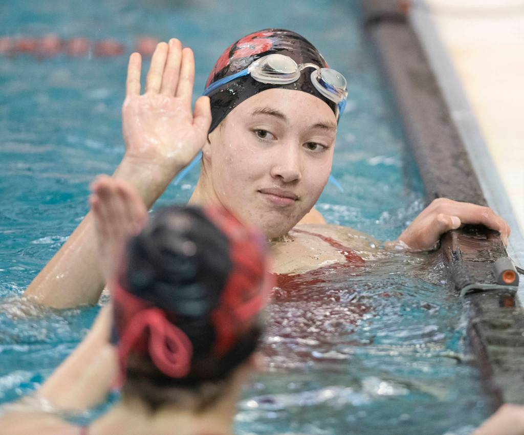 Juneau-Douglas Addy Mallot, top, gives a high-five to teammate Mesa Moran after competing in the 50 Yard Freestyle at the Juneau Invitational Swim Meet at the Dimond Park Aquatic Center on Friday, Sept. 20, 2019. (Michael Penn | Juneau Empire)