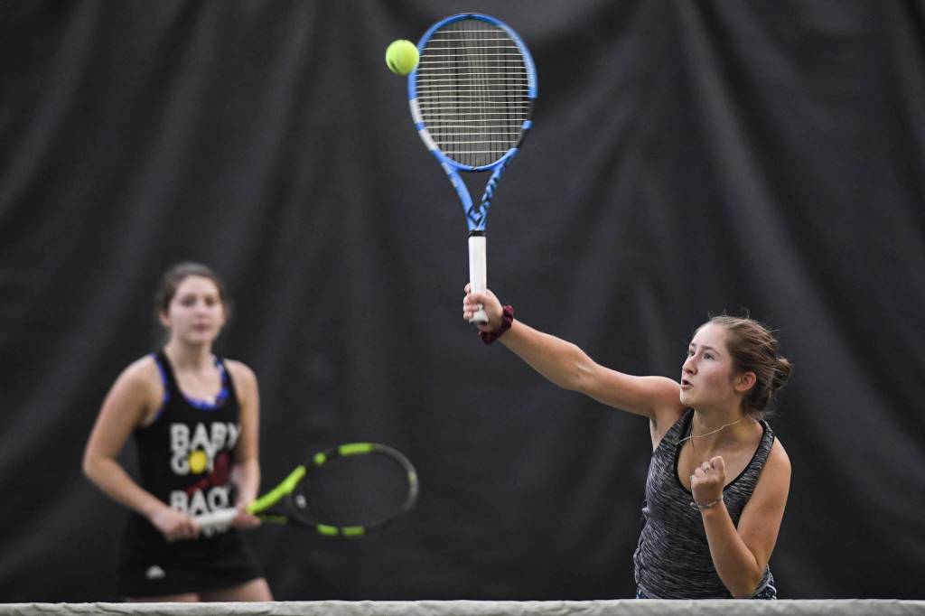 Adelie McMillan, right, hits an overhead as she plays in the girls doubles final with partner Olivia Moore against Jaymie Collman and Katie Pikul during the Region V Tennis Tournament at The Alaska Club/JRC on Saturday, Sept. 28, 2019. McMillan/Moore won 7-6, 6-4. (Michael Penn | Juneau Empire)