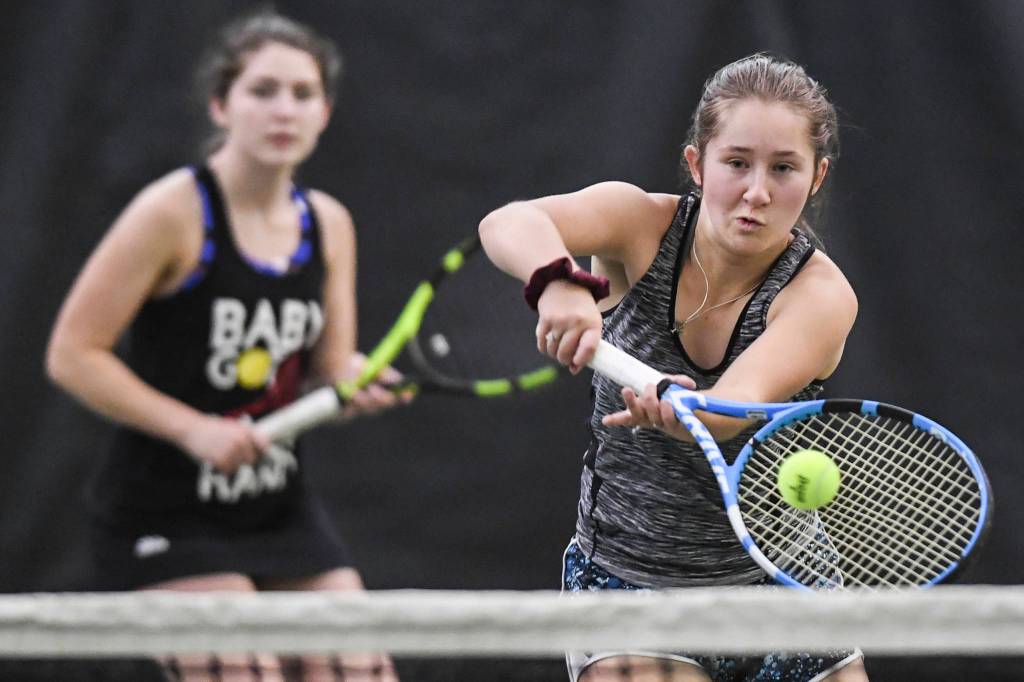 Adelie McMillan, right, hits a volley as she plays in the girls doubles final with partner Olivia Moore against Jaymie Collman and Katie Pikul during the Region V Tennis Tournament at The Alaska Club/JRC on Saturday, Sept. 28, 2019. McMillan/Moore won 7-6, 6-4. (Michael Penn | Juneau Empire)