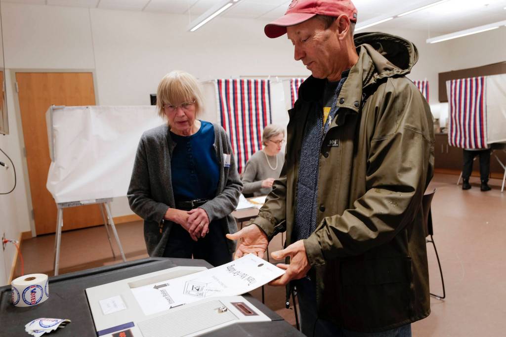 Election official Deborah Behr watches as Doug Woodby enters his ballot into a voting machine at the APK State Library, Archives and Museum Building on Tuesday, Oct. 1, 2019. (Michael Penn | Juneau Empire)