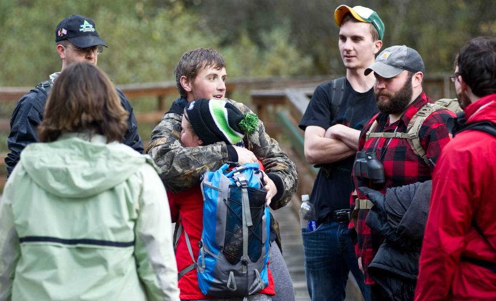 20-year-old Juneau resident Kevin Michaud, center, is hugged by his sister, Rachel Welsh, at the foot bridge to the Last Chance Mining Museum after being found by Juneau Mountain Rescue and SEADOGS searchers on Monday, Sept. 22, 2014. Michaud was lost overnight while hunting on Mount Roberts. (Michael Penn | Juneau Empire File)