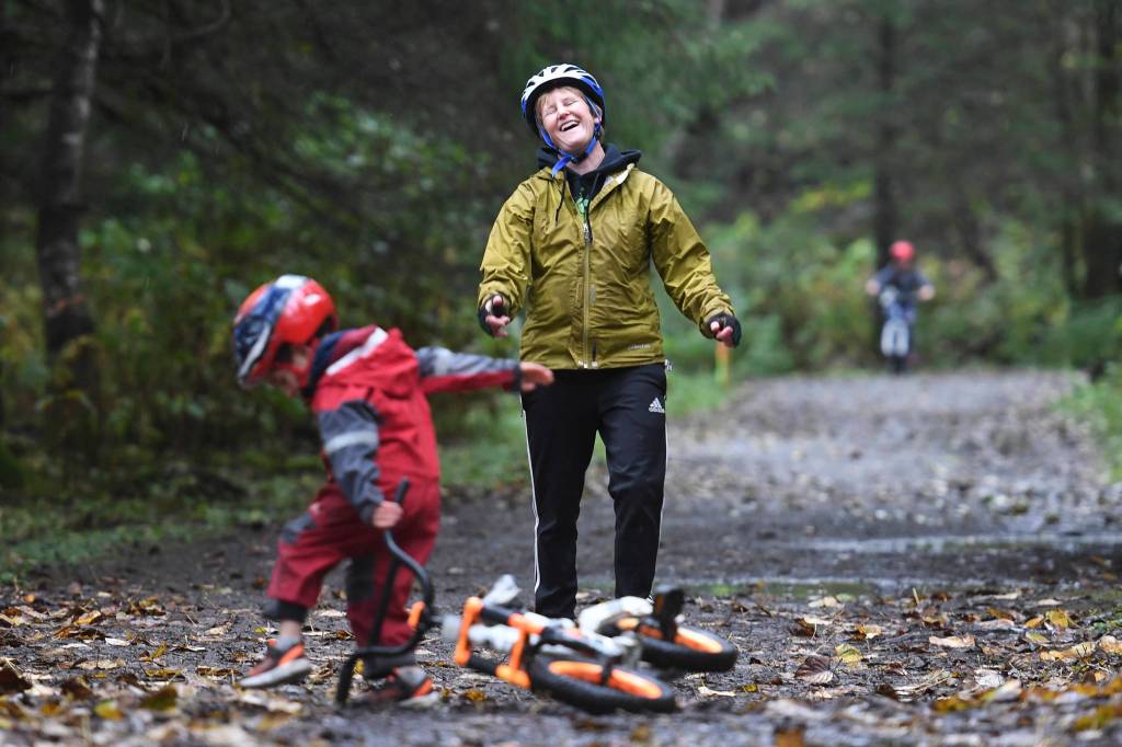 Joanna Quigg laughs as Joshua, 4, falls off his bike during the Douglas Dirt Derby Youth Bike Race at Savikko Park and the Treadwell Historic Trail on Saturday, Oct. 5, 2019. The event was organized by the Juneau Freewheelers Bicycle Club. (Michael Penn | Juneau Empire)