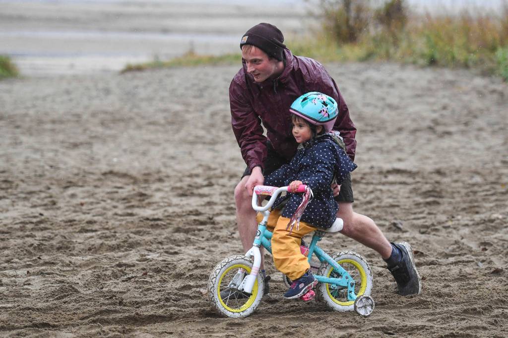 Dylan Kruger helps his daughter, Amelia, 4, at the finish of the Douglas Dirt Derby Youth Bike Race for 5 to 7-year-olds at Savikko Park and the Treadwell Historic Trail on Saturday, Oct. 5, 2019. The event was organized by the Juneau Freewheelers Bicycle Club. (Michael Penn | Juneau Empire)