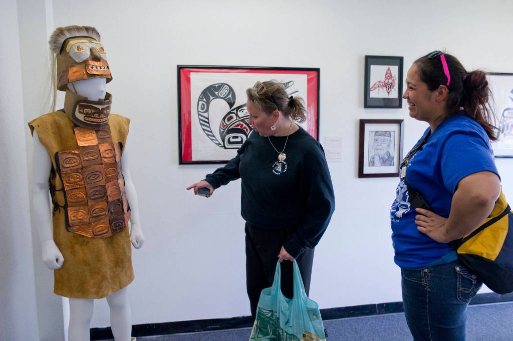 Divina Cole, right, and Kelly Coursey Gray admire the warriors helmet and armor made by 61 students at Dzantiki Heeni Middle School that won Juried Youth Art Award at the Juneau Arts and Culture Center as part of Celebration 2016. The juried art show is accepting applications. (Michael Penn | Juneau Empire File)