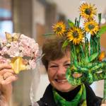 Mary Lou Gerbi, then-president of the Friends of the Alaska State Library, Archives, and Museum, holds two masks, that in October 2018 were autioned off during their Mask-erade event. This years event is scheduled for Oct. 19. (Michael Penn | Juneau Empire File)