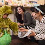 Corbin Hall, 2, receives a postcard from Rebecca Hsieh, right, and Kristen Cornell at Kindred Post for Halloween 2018. (Michael Penn | Juneau Empire)