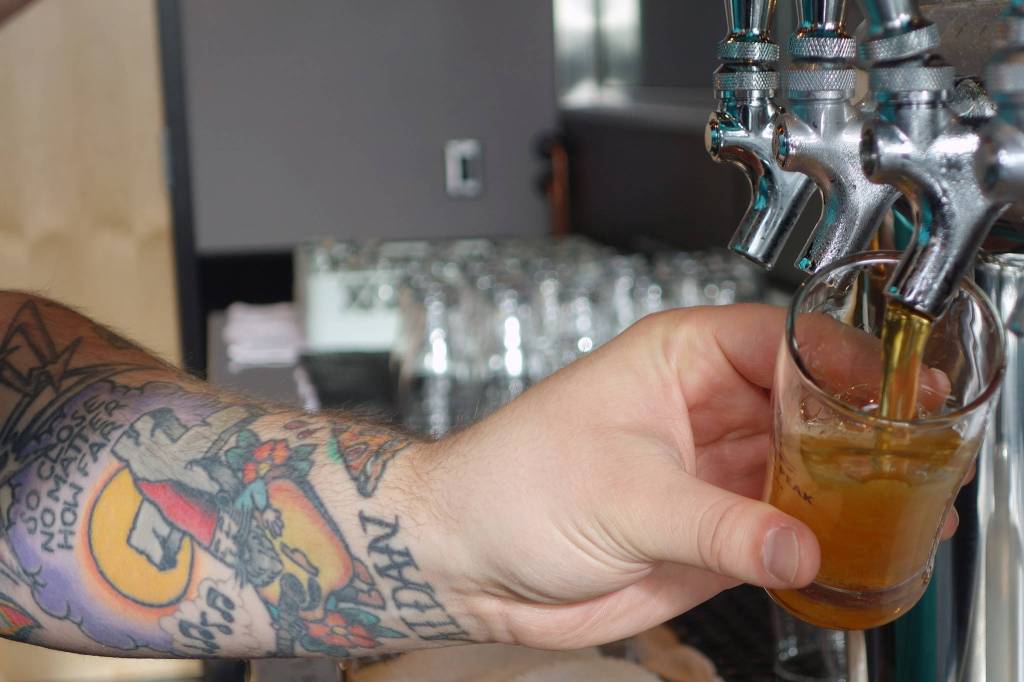 Zac Watt pours beer into a four-ounce glass for a beer flight during Forbidden Peak Brewerys grand opening, Saturday, Oct. 12, 2019. (Ben Hohenstatt | Juneau Empire)