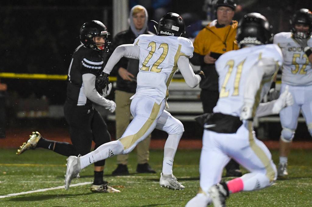 South Anchorages Aidan Ohlson, center, chases Juneaus Ali Beya at Adair-Kennedy Memorial Field on Saturday, Oct. 12, 2019. South Anchorage won 54-14. (Michael Penn | Juneau Empire)