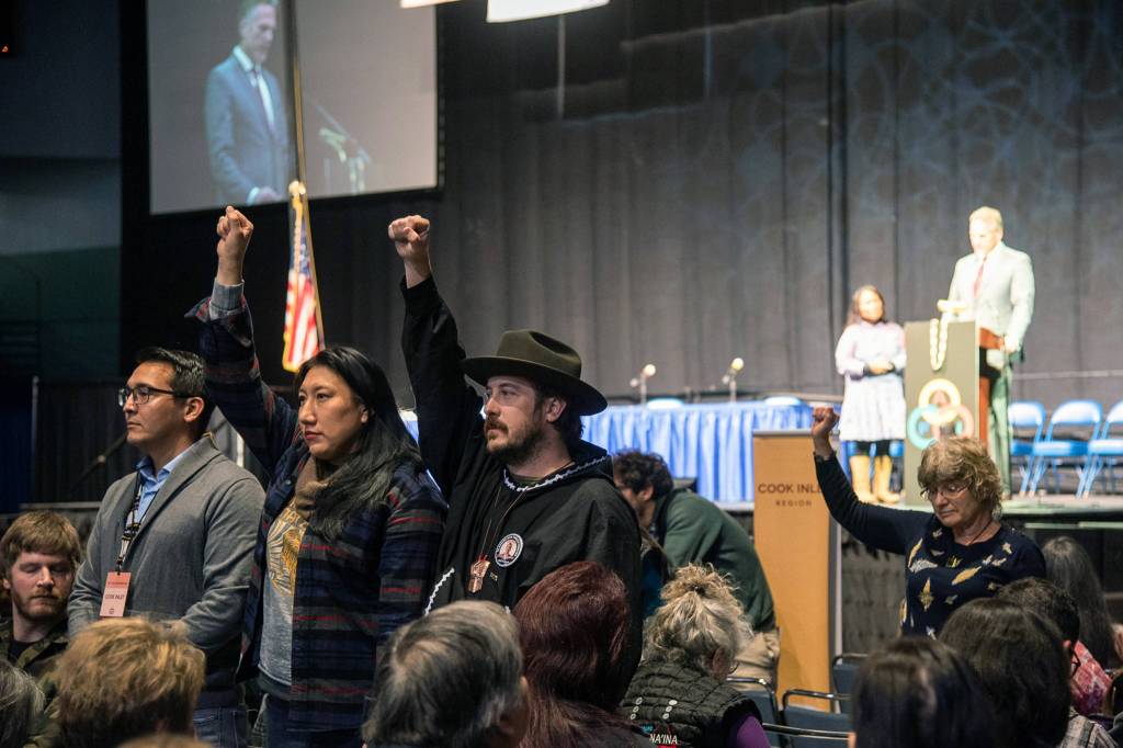 Protesters raise their fists during Gov. Mike Dunleavys speech at the Alaska Federation of Natives Contention, Thursday, Oct. 18,2019. (Courtesy Photo | Defend the Sacred Alaska)