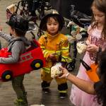 Raineka Ackley, parent educator with Parents as Teachers program, hands a Halloween treat to Denali, 3, as members of the program and children visited Juneau Pioneer Home to have an early Halloween with the residents on Tuesday, Oct. 22, 2019. (Michael S. Lockett | Juneau Empire)