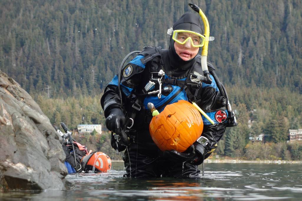 Sherry Tamone emerges from the water with her catfish jack-o-lantern at the sixth annual Spooktacular Dive and Underwater Pumpkin Carving event Saturday, Oct. 26, 2019. (Ben Hohenstatt | Juneau Empire)