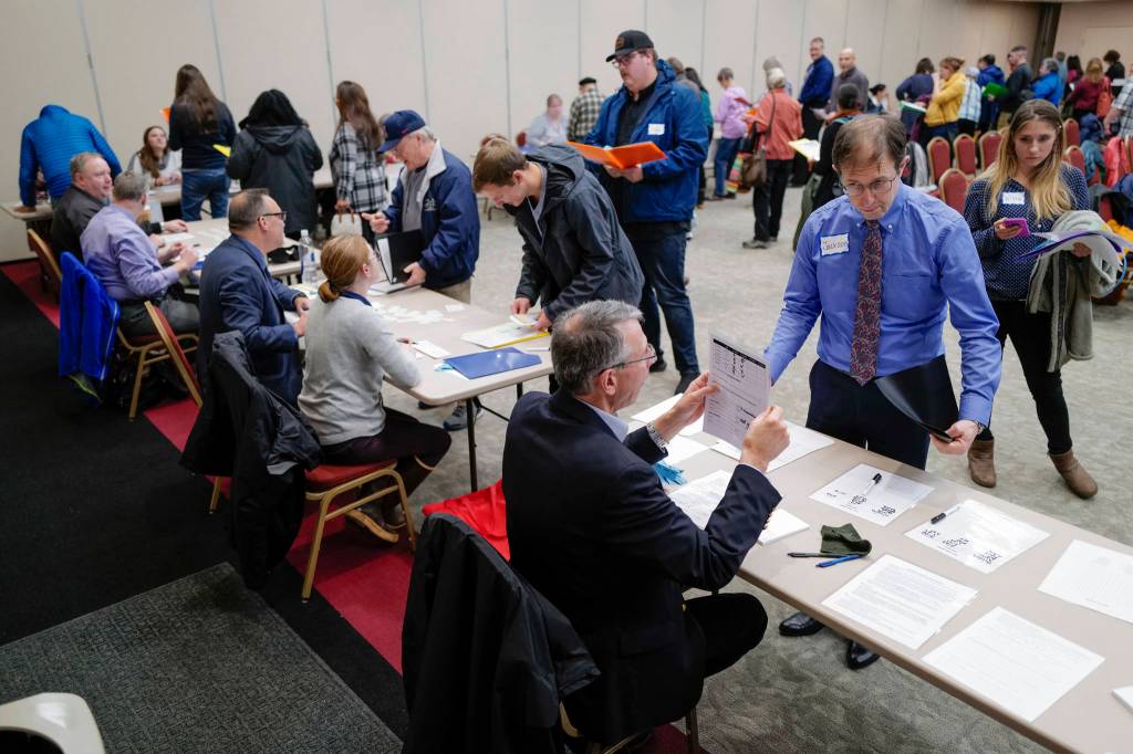 Sen. Jesse Kiehl, D-Juneau, right, visits the employer table manned by Don Habeger as he participates in a Reentry Simulation event at the Elizabeth Peratrovich Hall on Tuesday, Oct. 29, 2019. The event was sponsored by Central Council of the Tlingit & Haida Indian Tribes of Alaska in partnership with the Juneau Reentry Coalition and Alaska Mental Health Trust. (Michael Penn | Juneau Empire)