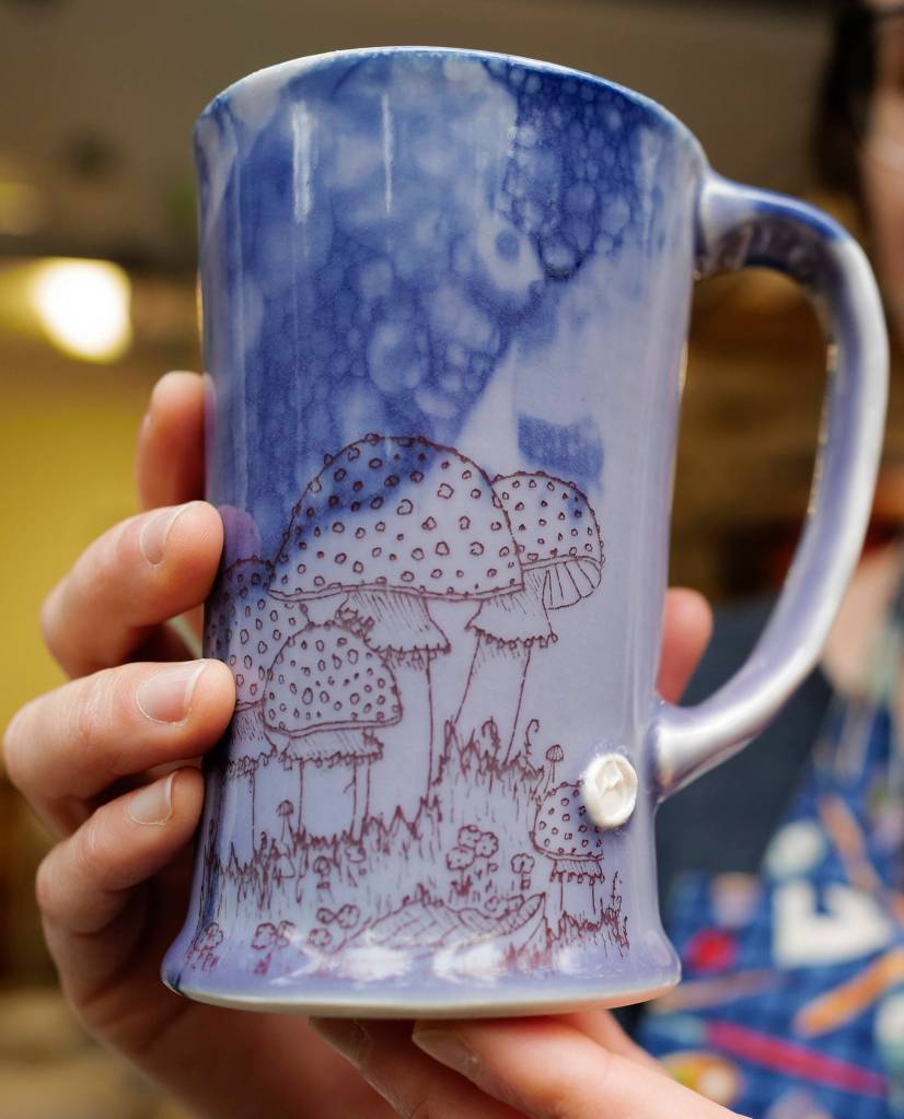 Mercedes Muñoz displays one of her mugs fresh out of her home studio on Monday, Oct. 28, 2019, as she prepares for a First Friday show at Coppa. (Michael Penn | Juneau Empire)