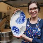Mercedes Muñoz holds a ceramic plate at her home studio on Monday, Oct. 28, 2019. Muñoz is showing her work at Coppa for First Friday. (Michael Penn | Juneau Empire)