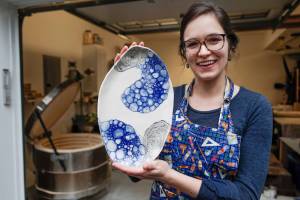 Mercedes Muñoz holds a ceramic plate at her home studio on Monday, Oct. 28, 2019. Muñoz is showing her work at Coppa for First Friday. (Michael Penn | Juneau Empire)