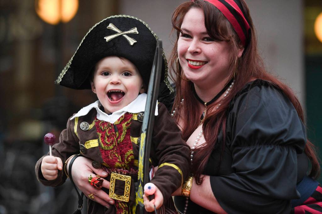 Gwen Peterson watches children with her son, Mason, 3, during the Trick or Treat Downtown event on Thursday, Oct. 31, 2019. More than 70 business put out orange balloons to participate in the event aimed at young children. (Michael Penn | Juneau Empire)