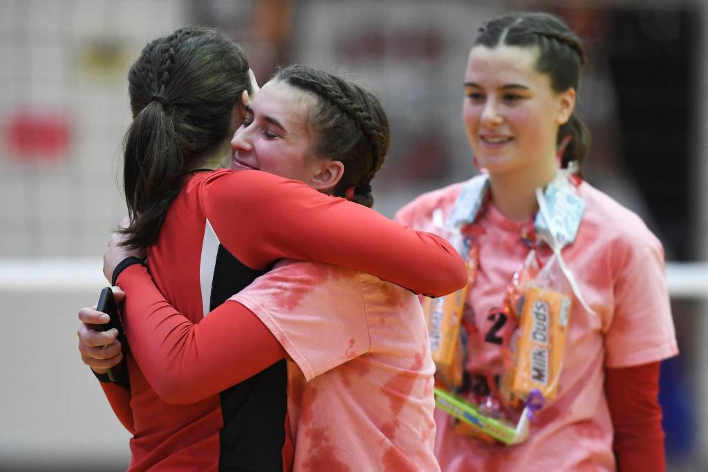 Juneau-Douglas senior Addie Prussing, center, receives a hug from Jenae Pusich as senior Abby Dean looks on during Senior Night at Juneau-Douglas High School: Yadaa.at Kalé on Friday, Nov. 1, 2019. ( Michael Penn | Juneau Empire)