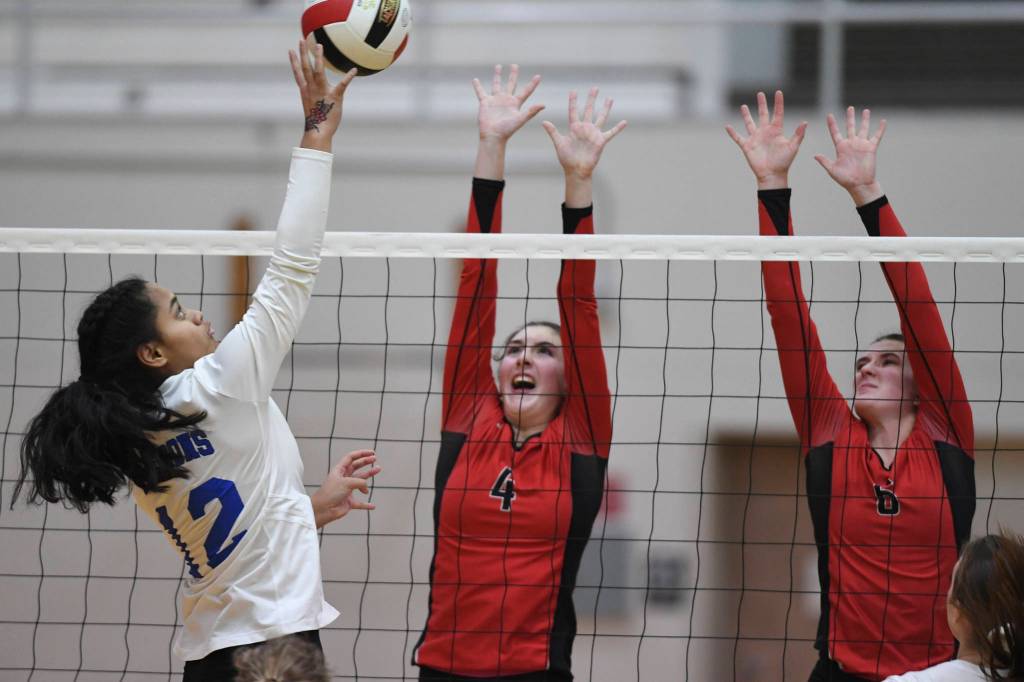 Thunder Mountains Mariah Tanuvasa-Tuvaifale places the ball over Juneau-Douglas Jenae Pusich center, and Addie Prussing at Juneau-Douglas High School: Yadaa.at Kalé on Friday, Nov. 1, 2019. Thunder Mountain won 3-0 (25-14, 25-20, 25-20). (Michael Penn | Juneau Empire)