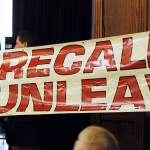 In this March 26, 2019, file photo, protesters unfurl a banner as Alaska Gov. Mike Dunleavy speaks during a roadshow with Americans for Prosperity in 49th State Brewing Company in Anchorage, Alaska. A fight is brewing over whether Dunleavy, a Republican who took office in Dec. 2018, should be recalled. Critics say hes incompetent and has recklessly tried to cut spending while supporters see a politically motivated attempt to undo the last election. (Bill Roth | Anchorage Daily News via AP)