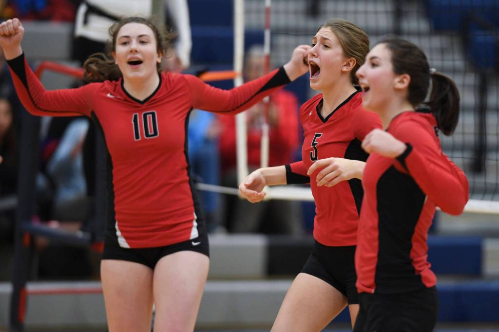 Juneau-Douglas Merry Newman, left, Brooke Sanford, center, and Kiana Potter celebrate a point against Ketchikan during the Region V Volleyball Tournament at Thunder Mountain High School on Thursday, Nov. 7, 2019. JDHS won 25-8, 25-14, 14-25, 25-15. (Michael Penn | Juneau Empire)