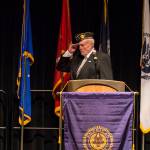 John D. Cooper, commander of the American Legion Auke Bay Post 25, salutes the flag as the colors are presented during a Veterans Day ceremony in Centennial Hall, Nov. 11, 2019. (Michael S. Lockett | Juneau Empire)