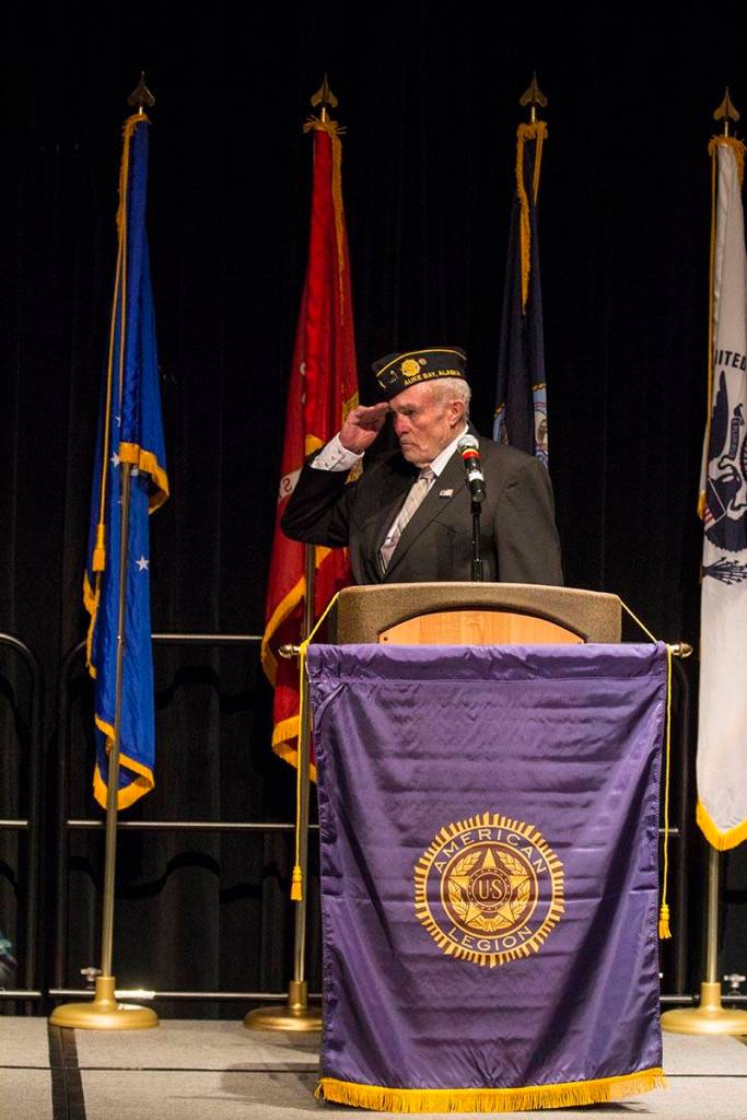 John D. Cooper, commander of the American Legion Auke Bay Post 25, salutes the flag as the colors are presented during a Veterans Day ceremony in Centennial Hall, Nov. 11, 2019. (Michael S. Lockett | Juneau Empire)