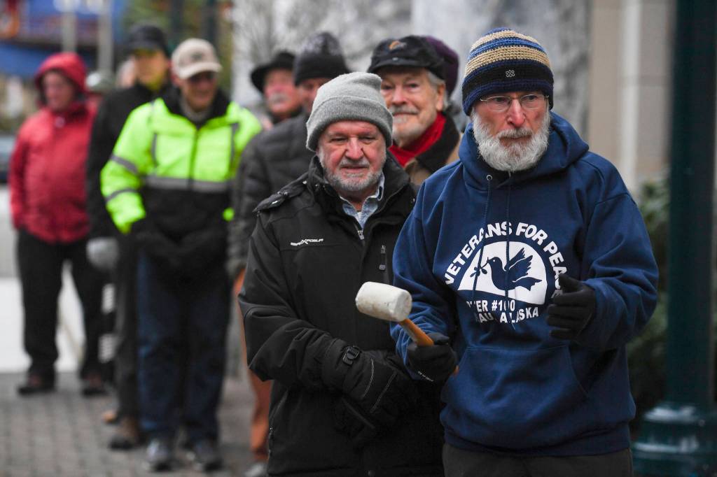 Paul DeSloover, right, and other members of Juneau Chapter of Veterans for Peace line up to ring Alaskas copy of the Liberty Bell in front of the Capitol on Monday, Nov. 11, 2019. (Michael Penn | Juneau Empire)