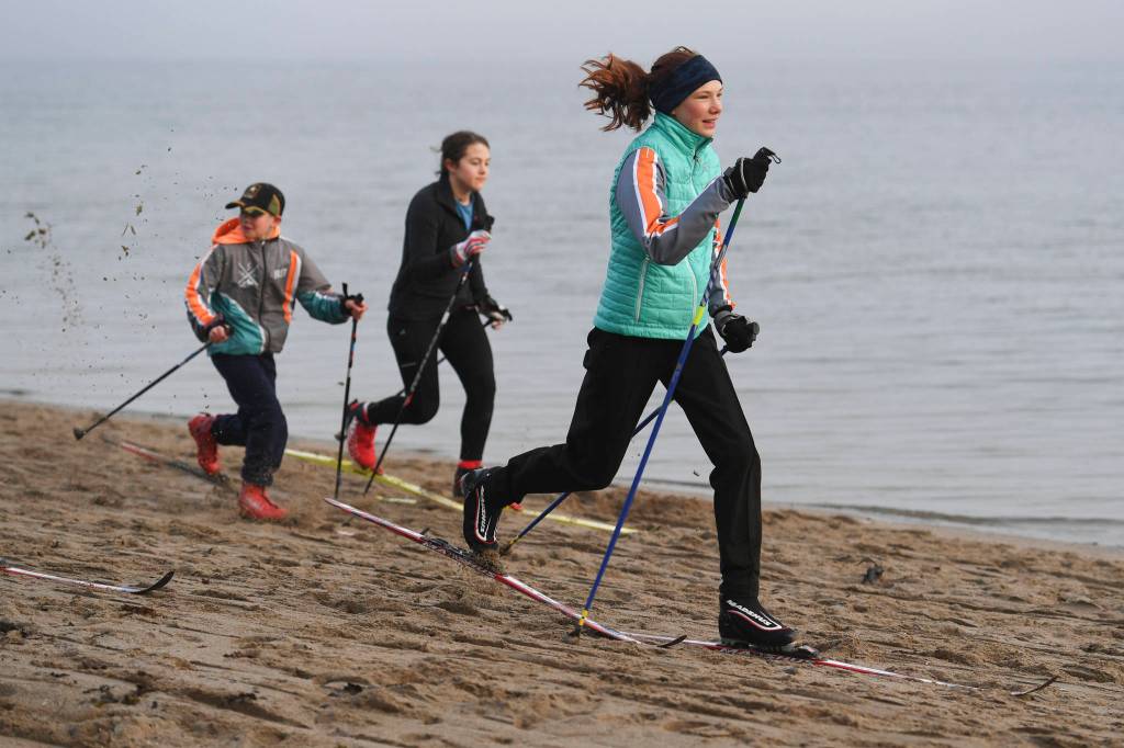 Annika Schwartz, right, Cecil Wheeler, center, and Nathan Creswell of the Juneau Nordic Ski Team practice at Sandy Beach on Friday, Nov. 8, 2019. The team, made up of middle and high school students, is finding alternative ways of training without snow as they prepare for their upcoming season. (Michael Penn | Juneau Empire)
