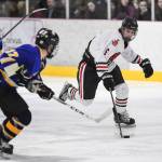 Juneau-Douglas Colter Polley moves the puck against Monroe Catholics Miles Fowler at the Treadwell Arena on Friday, Nov. 15, 2019. JDHS won 10-0. (Michael Penn | Juneau Empire)