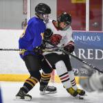 Juneau-Douglas Andre Peirovi, right, gets tied up against Monroes Dom Coiley in the second period at the Treadwell Arena on Friday, Nov. 15, 2019. JDHS won 13-0. (Michael Penn | Juneau Empire)