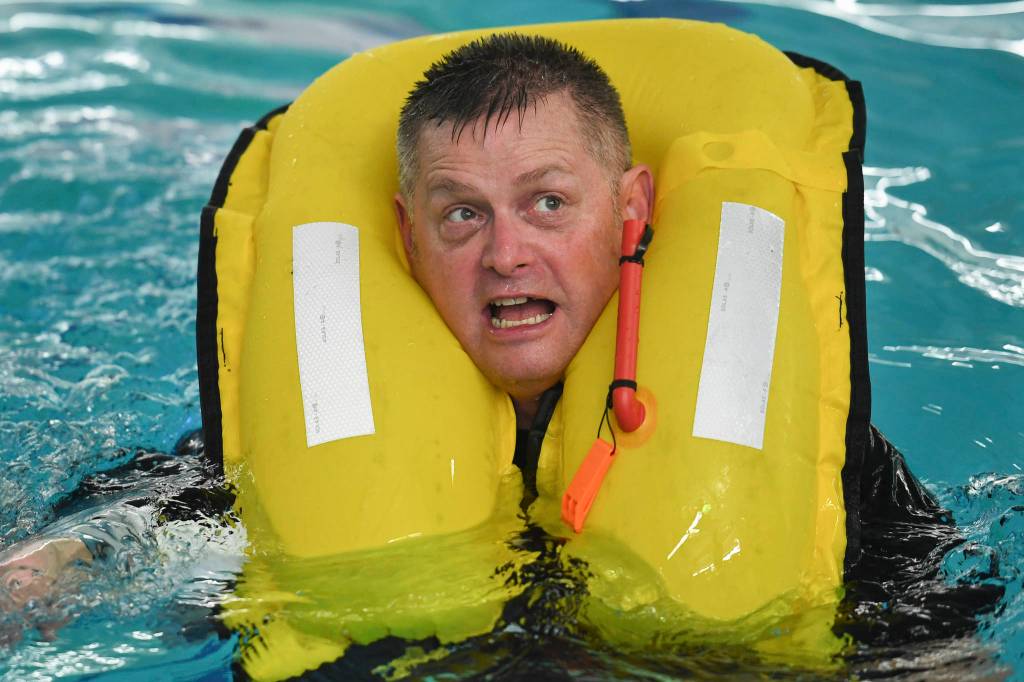 Lt. Cmdr. Kevin Dugan, a Coast Guards officer stationed in Juneau, takes a boating safety training class at the Augustus Brown Swimming Pool on Tuesday, Nov. 19, 2019. The class will qualify the members to teach students around the state about the use and importance of life vests. (Michael Penn | Juneau Empire)