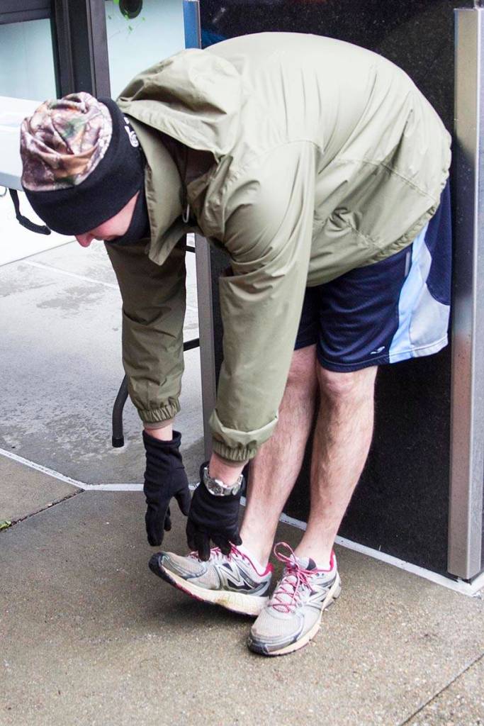 Chief Petty Officer Matt Schofield stretches before a Coast Guard 5K Turkey Trot through Juneaus harborfront on Nov. 22, 2019. (Michael S. Lockett | Juneau Empire)