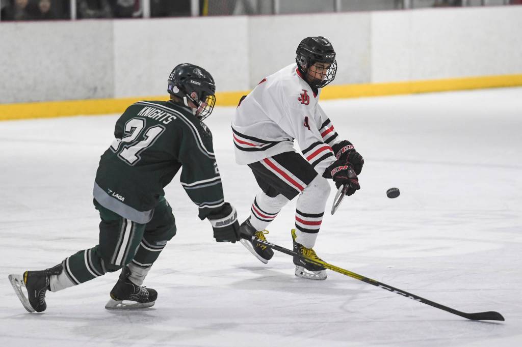 Juneau-Douglas Andre Peirovi, right, flicks the puck away from Colonys Jacob Ross at Treadwell Arena on Friday, Nov. 22, 2019. (Michael Penn | Juneau Empire)