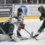 Juneau-Douglas Sam Bovitz competes against Colonys goalkeeper Bryant Marks, left, and Carson McLaughlin for control of the puck at Treadwell Arena on Friday, Nov. 22, 2019. (Michael Penn | Juneau Empire)