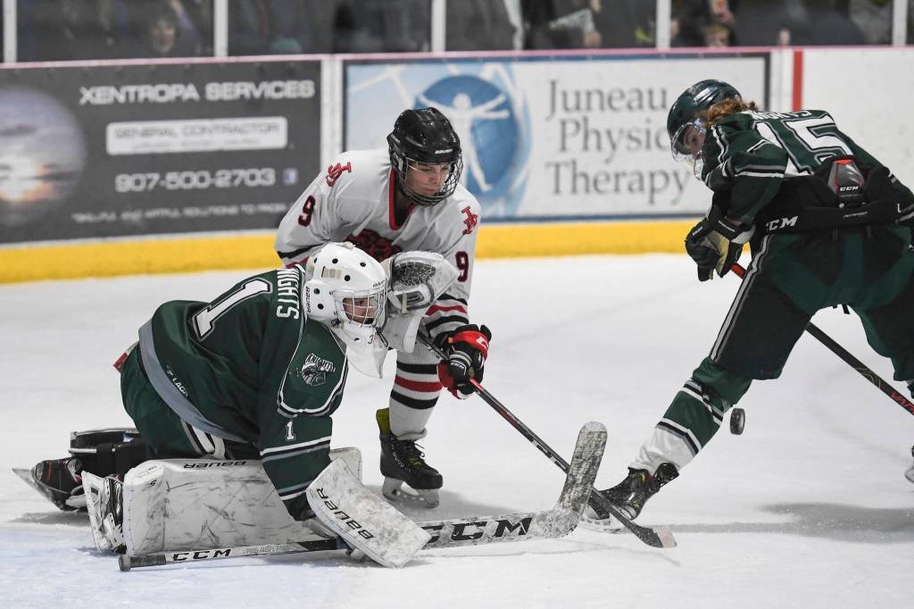 Juneau-Douglas Sam Bovitz competes against Colonys goalkeeper Bryant Marks, left, and Carson McLaughlin for control of the puck at Treadwell Arena on Friday, Nov. 22, 2019. (Michael Penn | Juneau Empire)