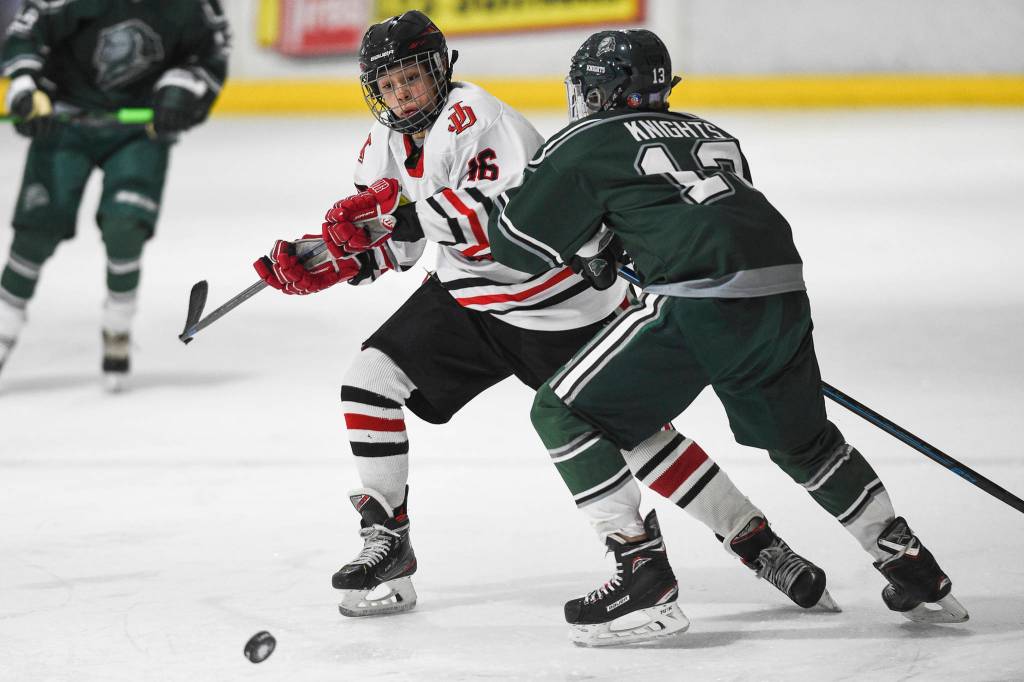 Juneau-Douglas Zac Stagg, left, moves the puck against Colonys Cauy Trangmoe at Treadwell Arena on Friday, Nov. 22, 2019. (Michael Penn | Juneau Empire)