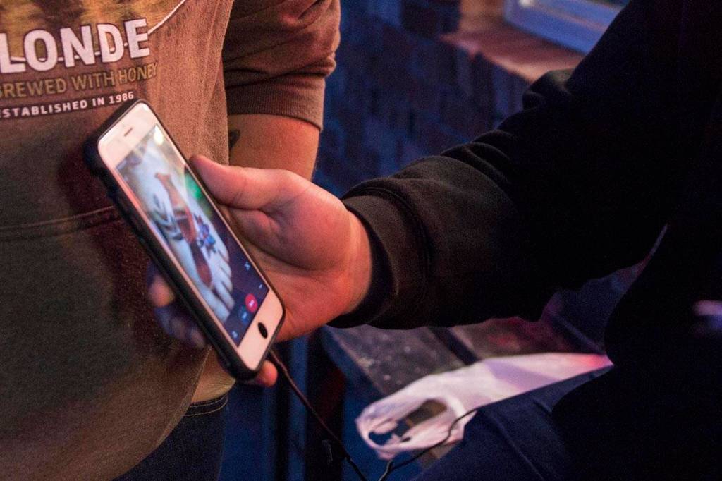 Sam Mason shows his design inspiration for a tattoo he planned to get, a robin, at Taku Tattoos International Suicide Survivors Day event on Saturday, Nov. 23, 2019. (Michael S. Lockett | Juneau Empire)