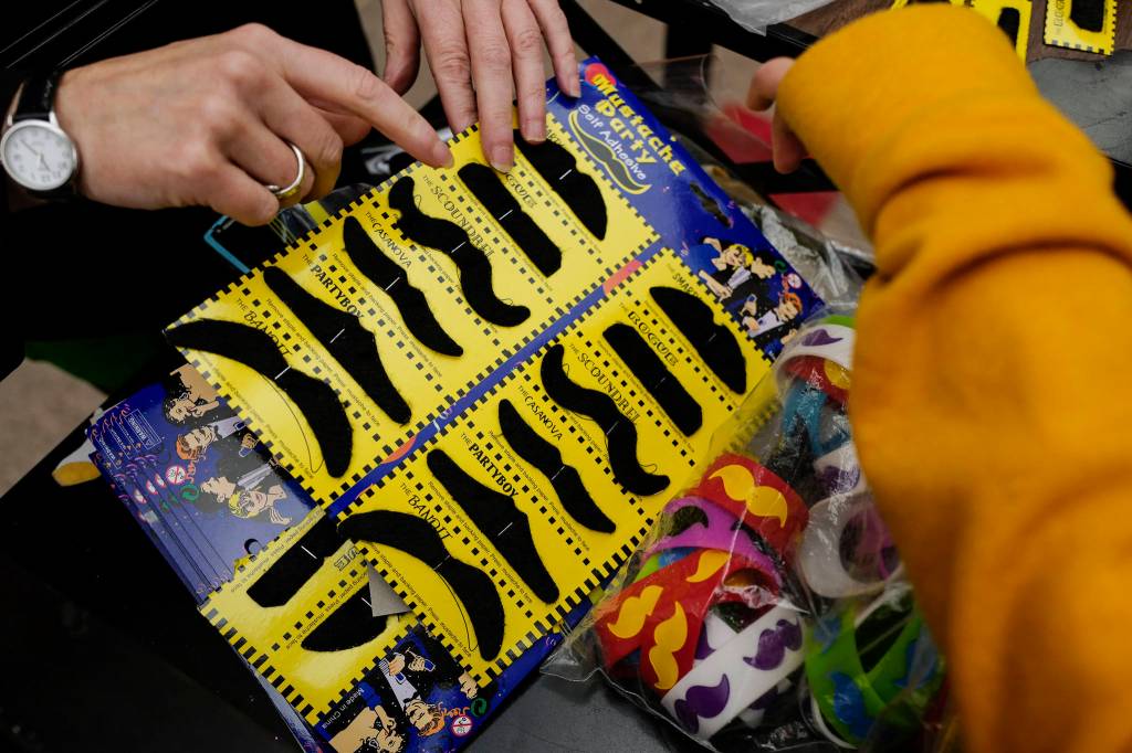 Barb Conant sells mustaches to students for Movember during their lunch hour at Floyd Dryden Middle School on Friday, Nov. 22, 2019. (Michael Penn | Juneau Empire)