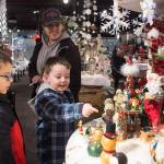 Delilah Bernaldo watches Kale Smith, 6, center, and Alec Muldoon, 4, as they look at the display at Holiday Village in the Alaska Shirt Company in December 2017. The village is a fundraiser for the Southeast Alaska Food Bank, Meals on Wheels, AWARE and The Glory Hall. (Michael Penn | Juneau Empire File)