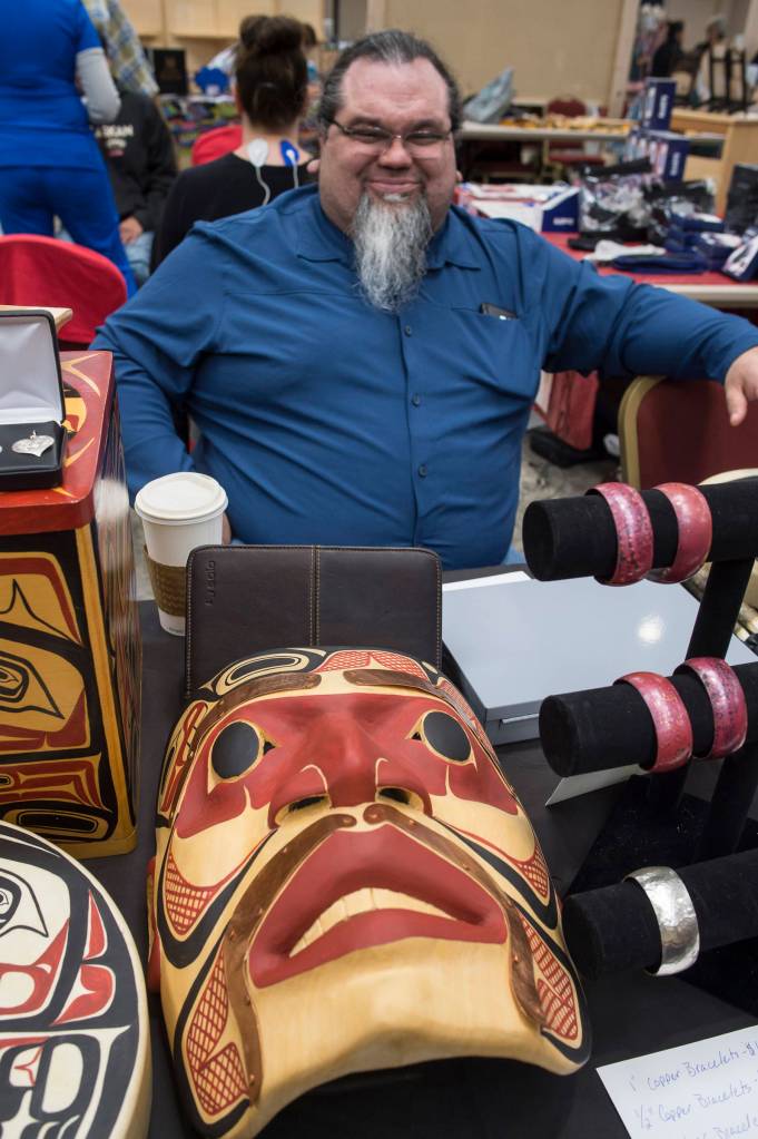 Tsimshian artist Abel Ryan waits for customers at the Public Market in the Elizabeth Peratrovich Hall on Friday, Nov. 23, 2018. (Michael Penn | Juneau Empire File)