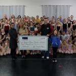 Mike Satre, manager of government and community relations for Hecla Greens Creek Mining Co., accompanied by daughter Miriam, present a $5,000 check to Juneau Dance Theatre, as a Principal Season Sponsor, for the organization on Nov. 23. JDT board members, Gwen Rivas, left, and Dawn Jouppi, right, along with the cast of 90 dancers in The Nutcracker, accepted the donation.