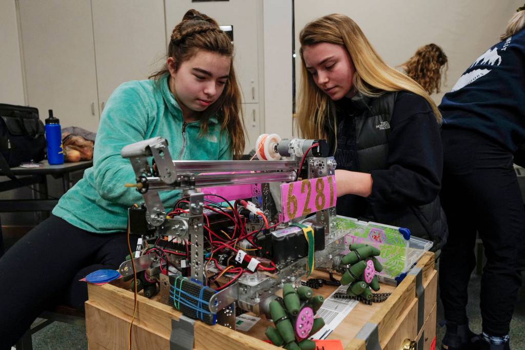 Freshman Kristie Kulbeth, left, and senior Rylee Larson, of the team Genetic Advantage, work on building their robot during practice for the Thunder Mountain High School robotics team at TMHS on Thursday, Dec. 5, 2019. (Michael Penn | Juneau Empire)