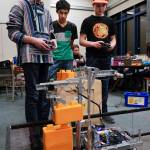 Junior Remington Wiley, left, freshman Jaman Goh, center, and junior Keelan Cunningham, of the team Chain Reaction, watch their robot stack blocks during practice for the Thunder Mountain High School robotics team at TMHS on Thursday, Dec. 5, 2019. (Michael Penn | Juneau Empire)
