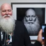 Mike Gates of Ketchikan has his picture taken by friend Dan Dawson in front of his self portrait at the Alaska Positive juried photography exhibit at the Alaska State Museum during Gallery Walk on Friday, Dec. 6, 2019. Gates received an Award of Recognition for his self portrait. (Michael Penn | Juneau Empire)