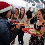 Adelie McMillian, right, Lydia Powers, center, and Dominique Morley, all members of figure skating team, serve trays of treats to visitors to the Senate Building during Gallery Walk on Friday, Dec. 6, 2019. (Michael Penn | Juneau Empire)