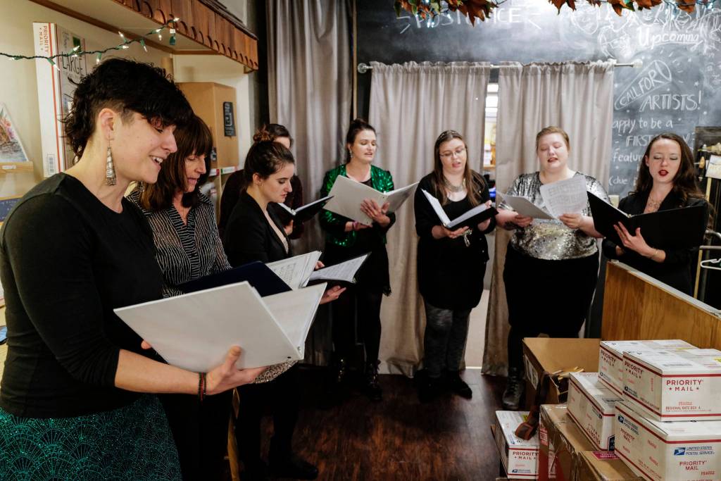 Members of the Bell Bell Bell sing at Kindred Post during Gallery Walk on Friday, Dec. 6, 2019. (Michael Penn | Juneau Empire)