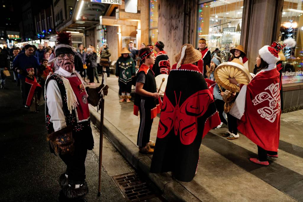 Walter Soboleff, left, sings with the Yees ku.oo Dancers on Front Street during Gallery Walk on Friday, Dec. 6, 2019. (Michael Penn | Juneau Empire)